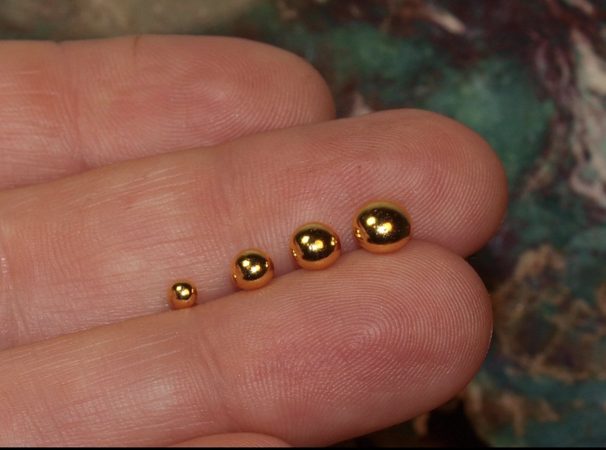 Hand holding 3mm, 4mm, 5mm, and 6mm solid 24K gold ball stud earrings